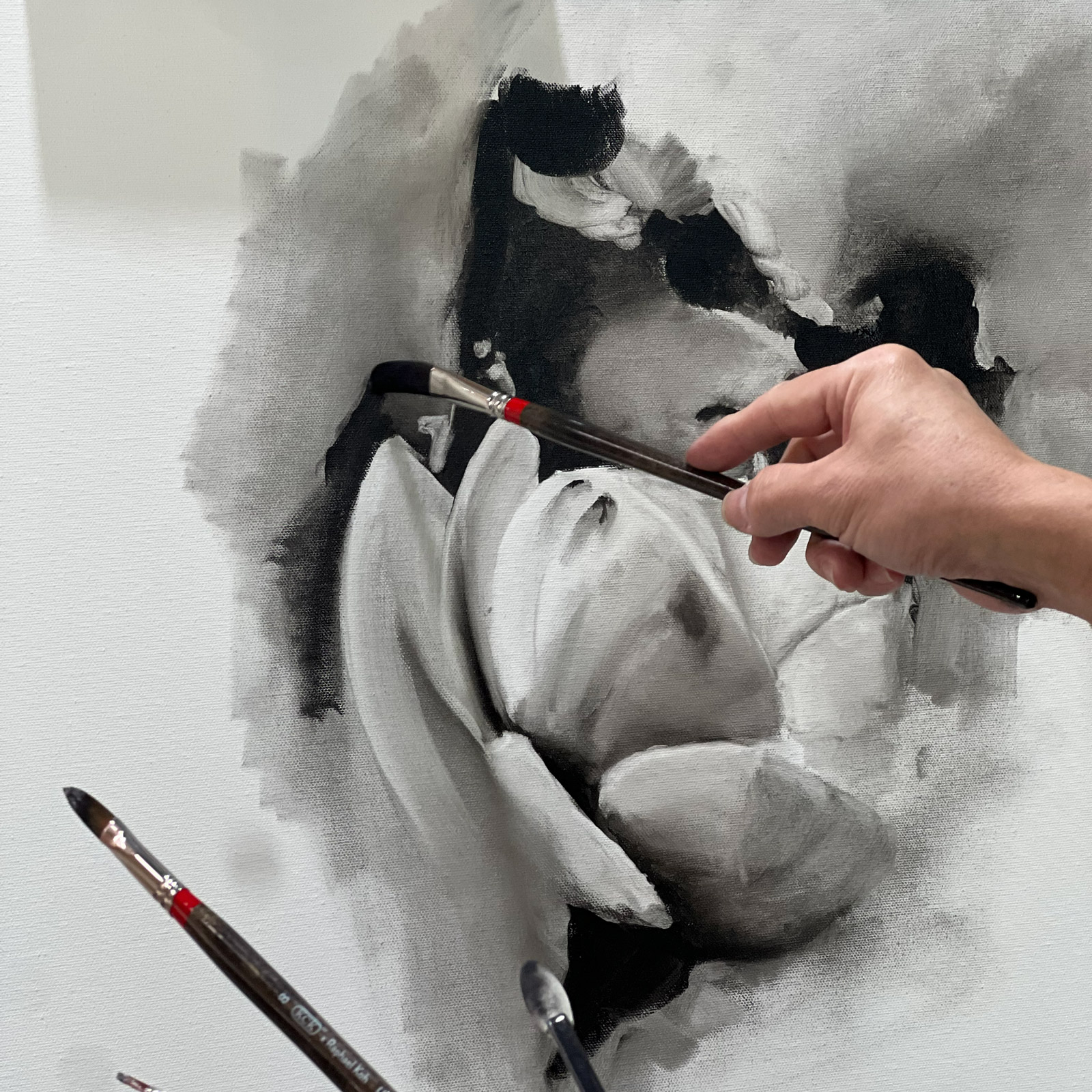 An artist working on a charcoal portrait
